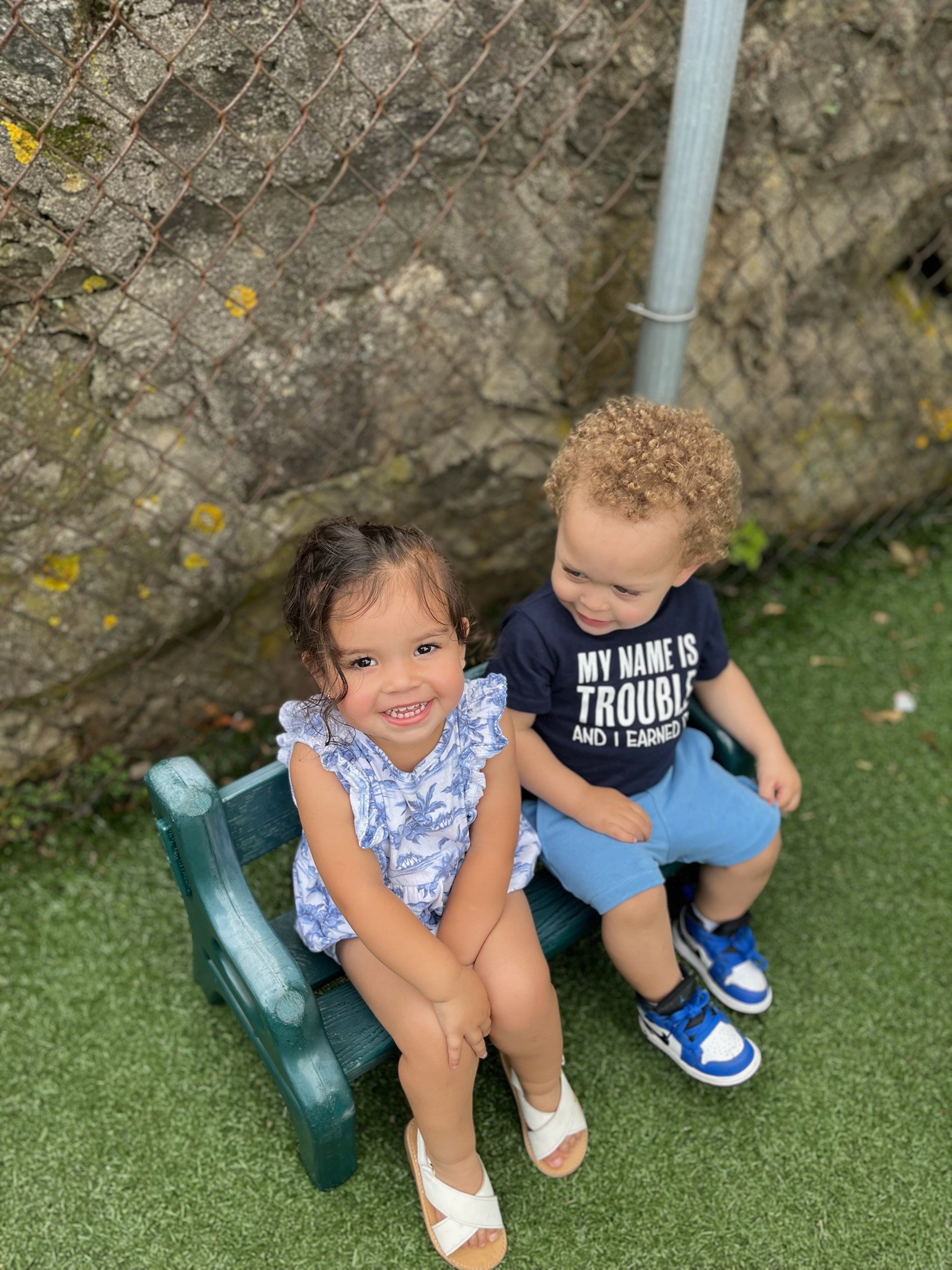 Two toddlers sitting together on a bench