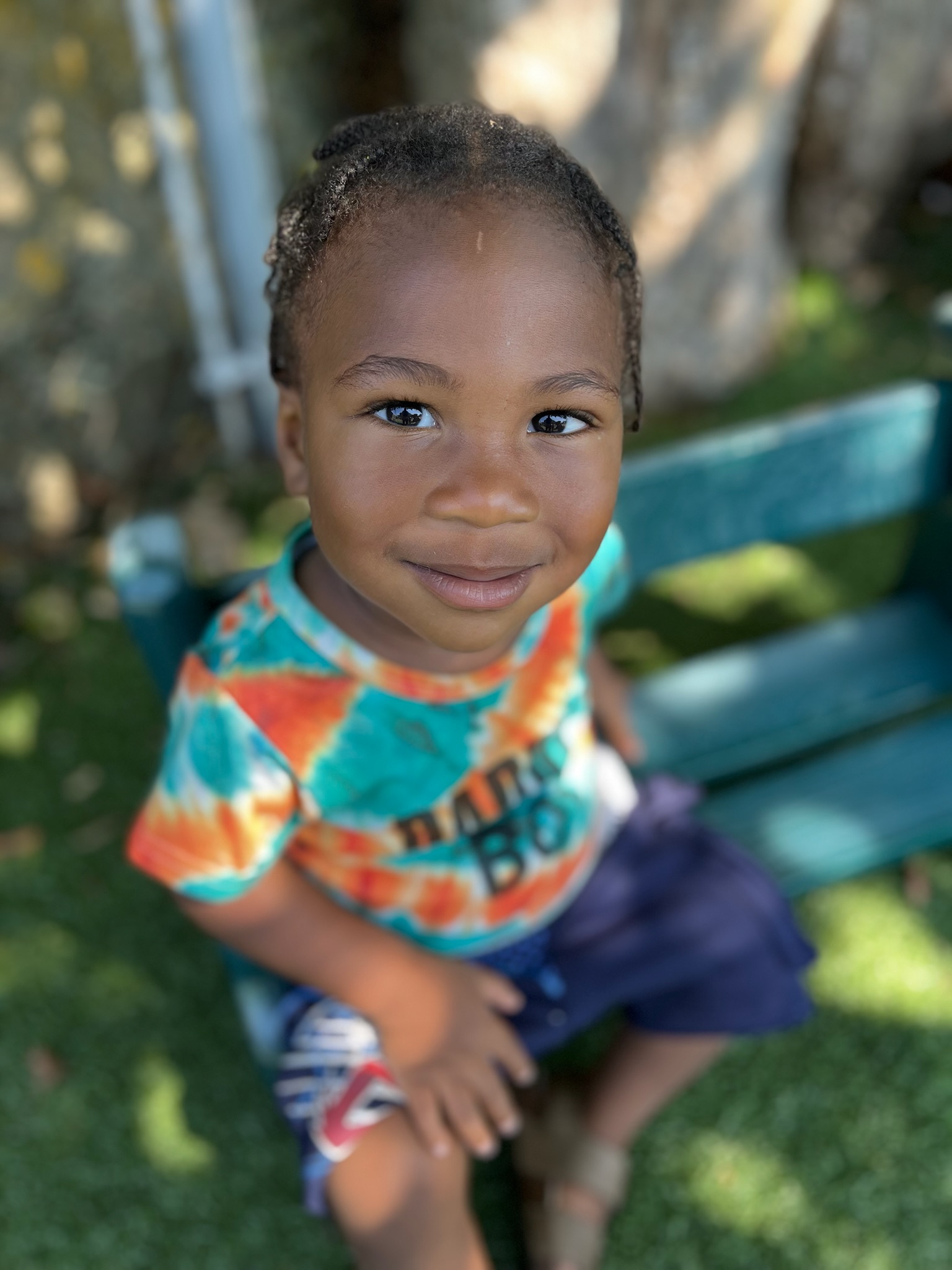 Toddler smiling in colorful tie-dye shirt