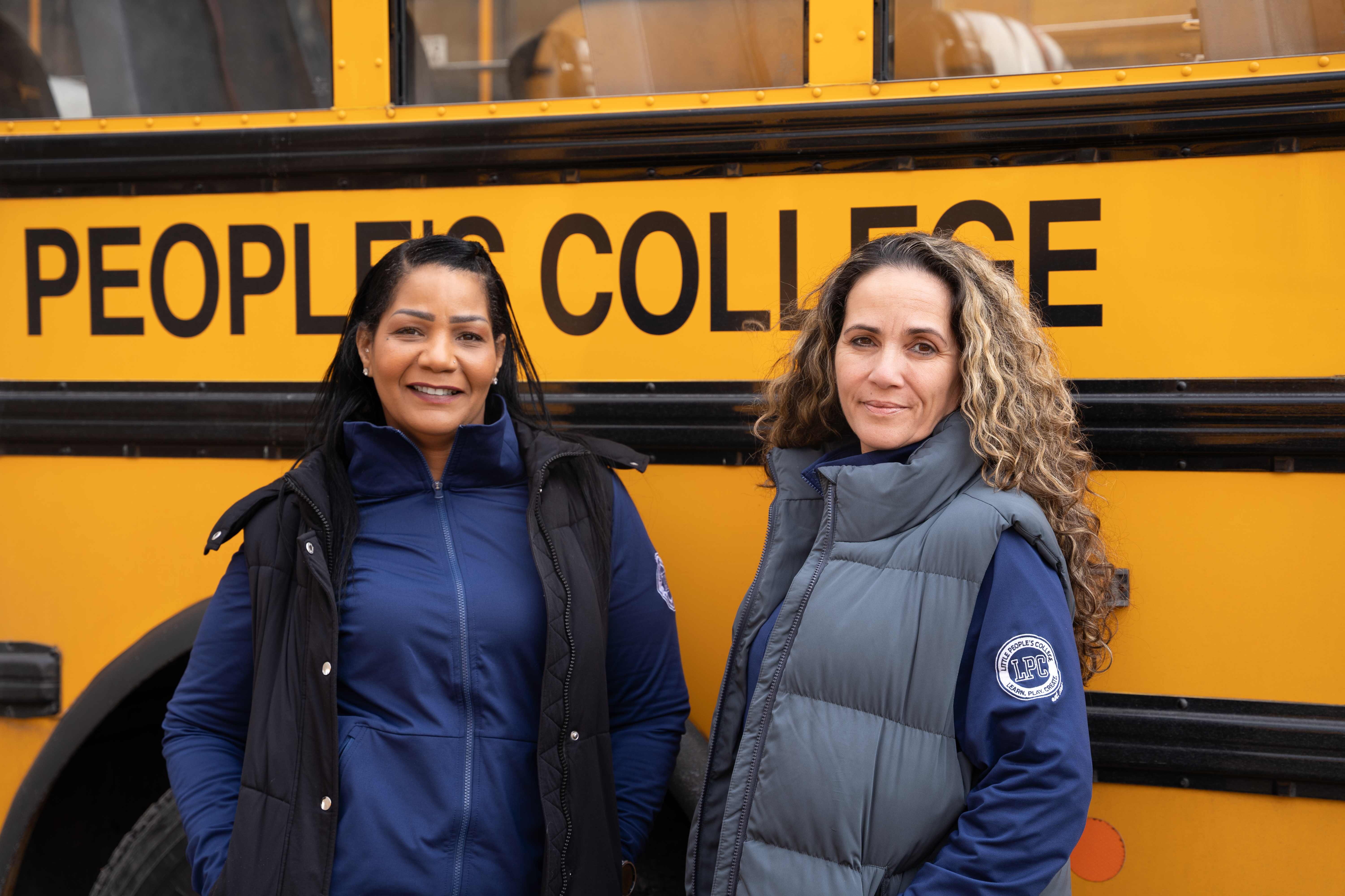Karen Rogers and Alicia Bettencourt, LPC Transportation Co-Directors, in front of an LPC school bus